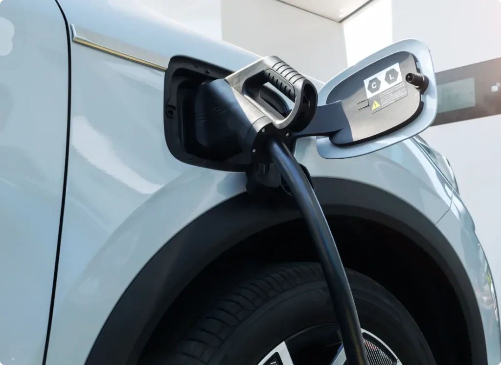 ev & hybrid repair, auto repair in West Point, VA at Eltham Auto Clinic. Close-up of an electric vehicle being charged, showing the charging cable plugged into the car’s charging port.