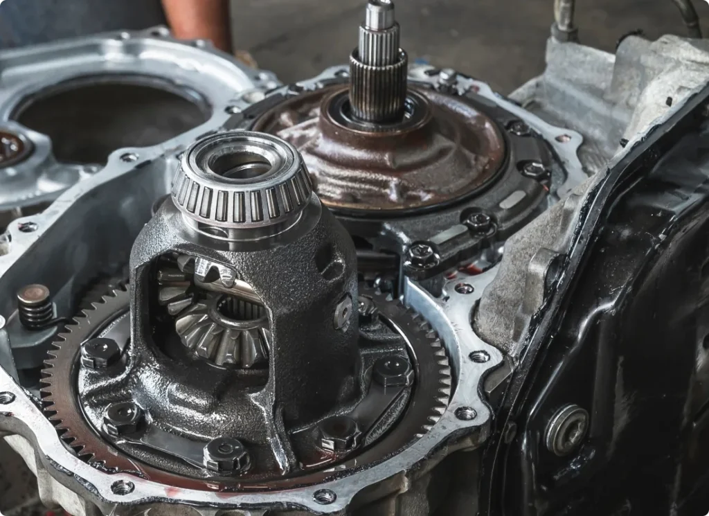 transmission repair, auto repair in West Point, VA at Eltham Auto Clinic. Close-up view of the inner components of an automotive transmission system, showing gears, bearings, and metal parts with a metallic and slightly oily appearance.