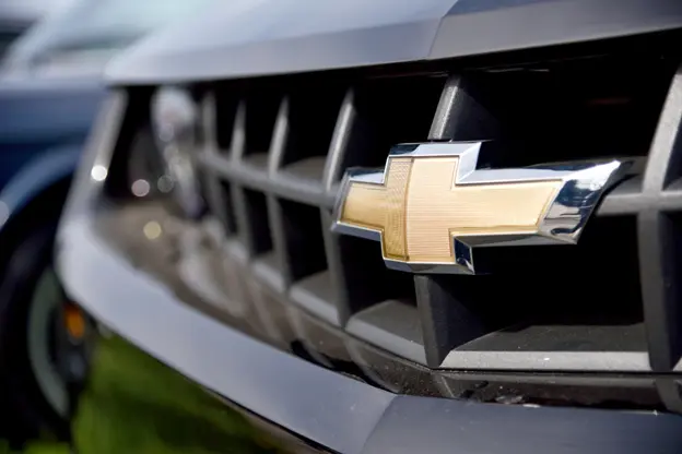 Chevrolet emblem on the front grille of a vehicle, showcasing a close-up of the iconic gold bowtie badge on a dark background.
