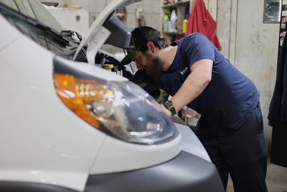 Pre-Holiday Car Check in West Point, VA At Eltham Auto Clinic. Mechanic inspecting a vehicle engine during a pre-holiday winter safety check