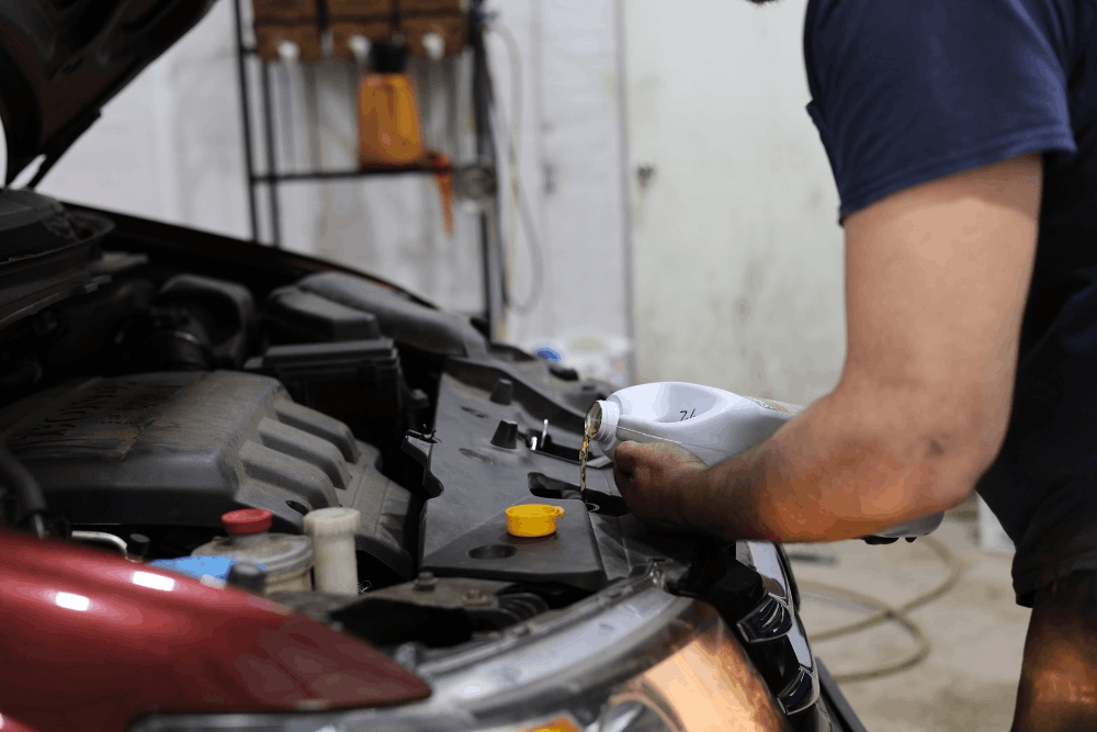Car care, auto repair in West Point, VA at Auto Clinic. Image of a technician adding coolant during a cooling system inspection to help prevent engine overheating, maintain proper operating temperatures, and support long-term vehicle reliability.